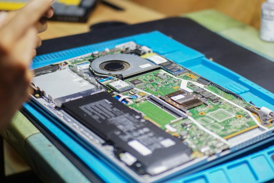 Close-up of laptop being repaired with visible components and tools.