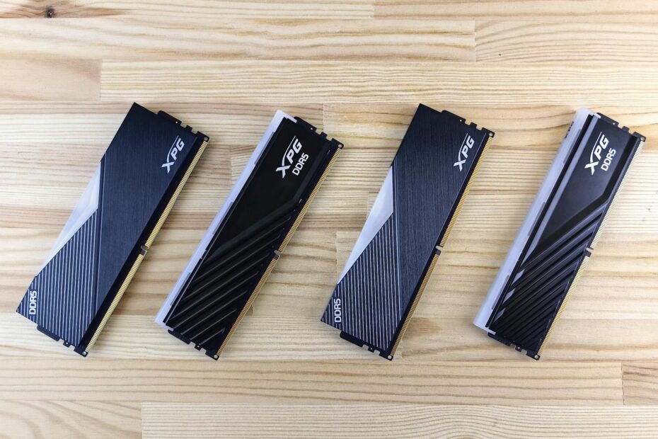 Four XPG DDR5 RAM modules aligned on a wooden surface, showcasing modern computing technology.