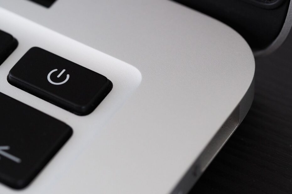 Detailed view of a power button on a sleek laptop, emphasizing technology design.