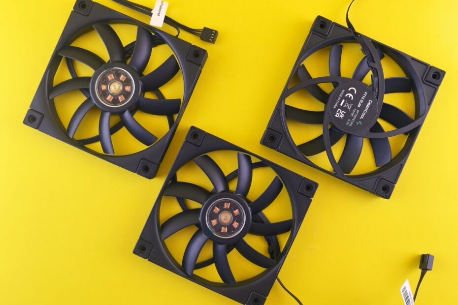Three black computer cooling fans arranged on a vivid yellow backdrop, perfect for tech themes.