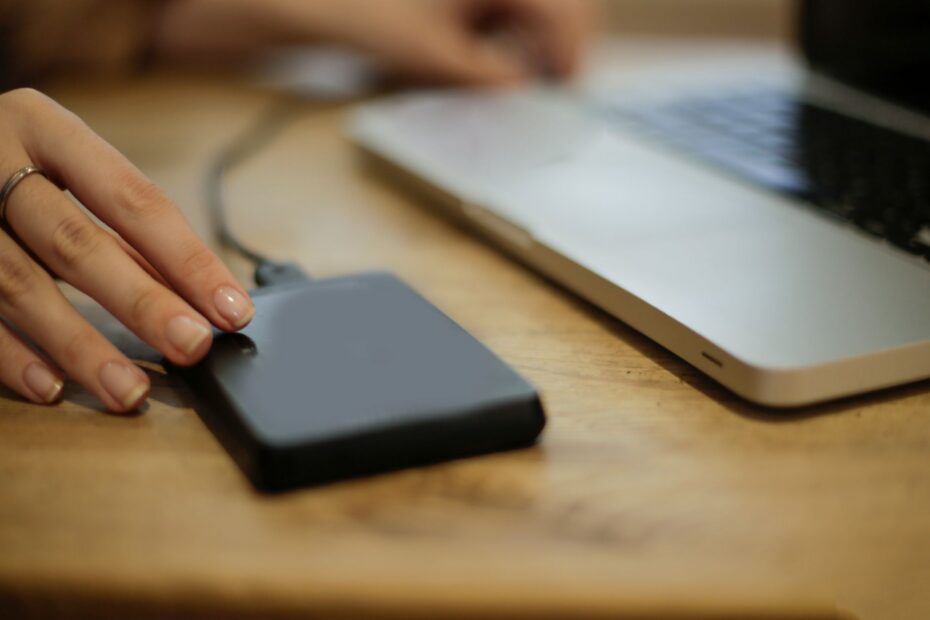 Εξωτερικός σκληρός δίσκος USB συνδεδεμένος σε θύρα φορητού υπολογιστή σε γραφείο.